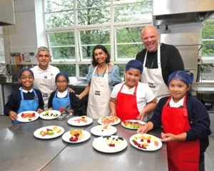 Sadiq Seema Tom with schoolchildren